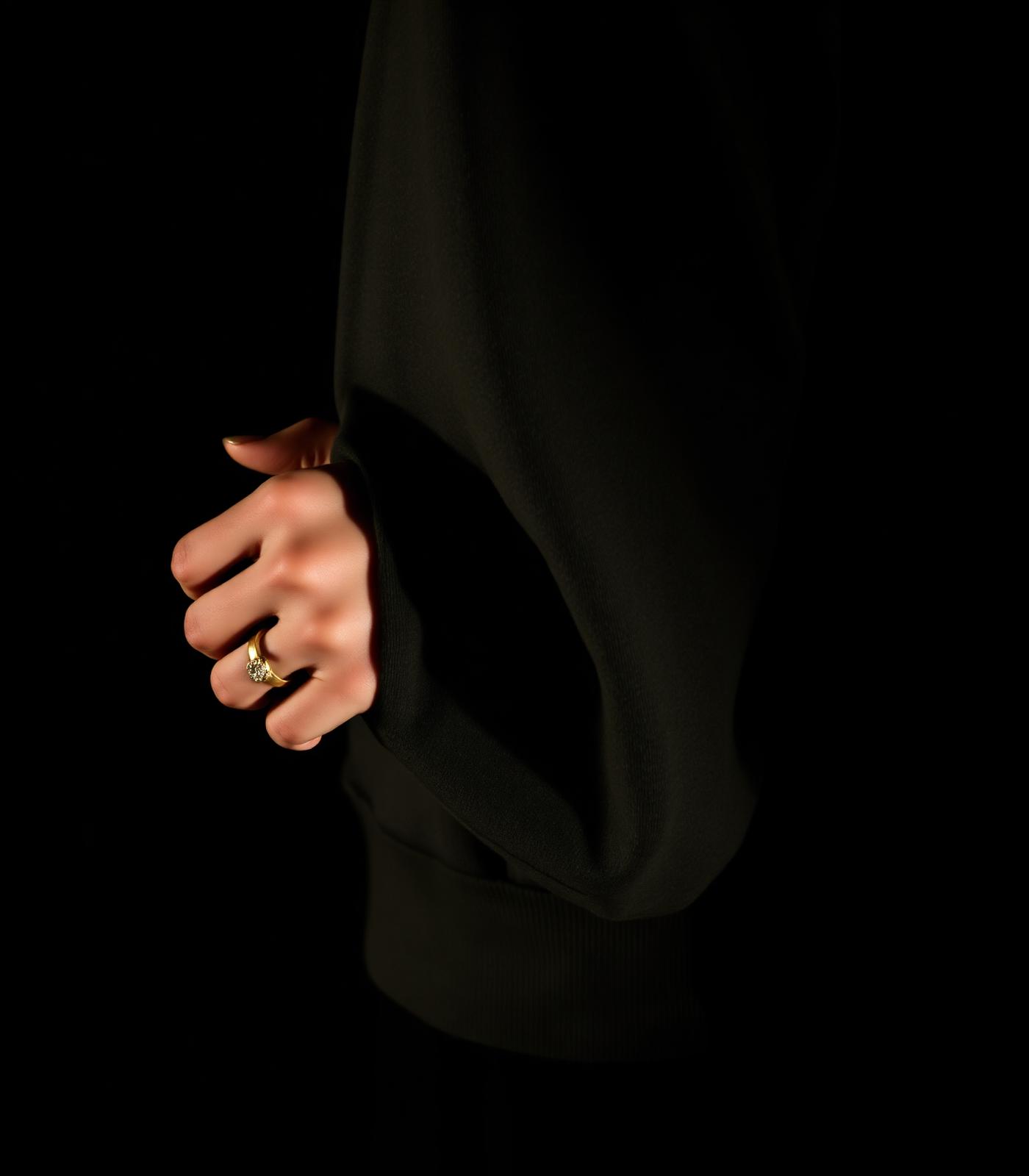 Detail of an oversized hoodie sleeve with a gold ring
